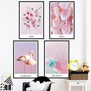 Pink flamingo and beach shells 4-piece framed wall art set in a cozy bedroom setting