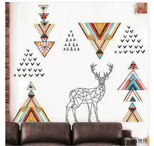 Detail of geometric reindeer wall sticker with colorful triangles above a brown sofa