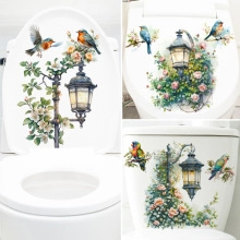 Detail of floral bird decals on a white toilet lid with vintage street lamp and pink roses