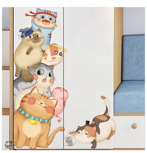 Detailed view of cute cartoon cat wall decals applied on a white bedroom cabinet surface