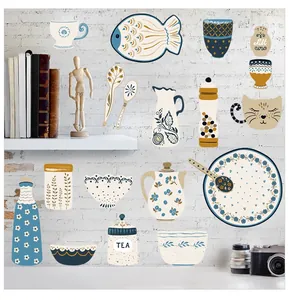 Close-up of cute kitchen wall decals featuring tea pots and bowls on white brick wall