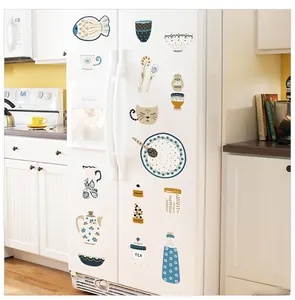 Detail of Nordic kitchen wall stickers with fish and teapot patterns on a white fridge