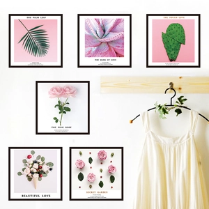 Pink floral and palm leaf wall art prints in black frames for minimalist bedroom decor