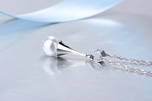 Detailaufnahme eines eleganten Perlenanhängers an einer feinen silbernen Kette