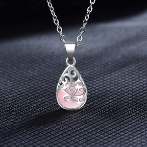Détail macro du pendentif goutte argenté avec pierre œil de chat rose sur chaîne