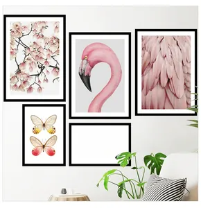 Modern pink flamingo and magnolia wall art set with black frames in a cozy living room