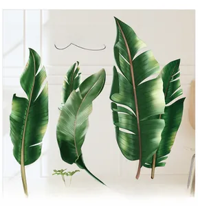 Détail de stickers muraux feuilles tropicales réalistes sur une surface murale blanche