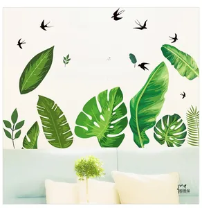 Detail view of tropical leaf wall stickers and birds on a clean white living room wall