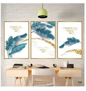 Detail of tropical banana leaf wall art set with golden frames on white brick wall