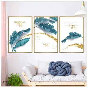 Detailed view of three-piece tropical banana leaf wall art in minimalist gold frames