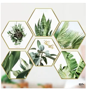 Detail view of hexagonal Nordic wall art set with green leaves and gold frames