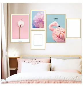 Modern pink flamingo and white floral wall art set with golden frames on bedroom wall