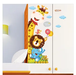 Détail de stickers muraux girafe et lion sur une armoire de chambre d'enfant blanche