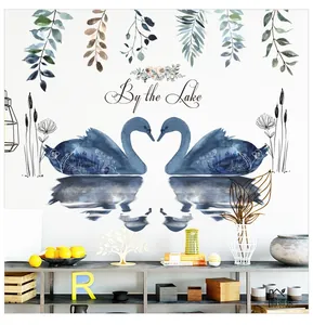 Detail view of heart-shaped blue swans wall sticker with By the Lake text and green leaves