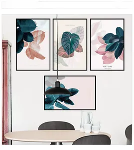 Modern pink and green leaf wall art set with black frames in a minimalist room setup