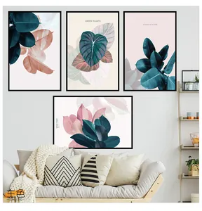 Detail of four Nordic leaf art prints with black frames above a living room sofa
