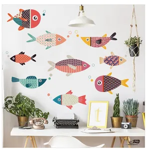 Detail of colorful geometric cartoon fish wall stickers in a minimalist Nordic room setup