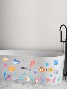Bunte Aquarell-Meeresfisch-Wandaufkleber auf einer weißen Badewanne im modernen Bad