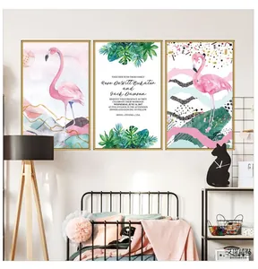 Detail of Nordic wall art featuring pink flamingos and tropical leaves in gold frames