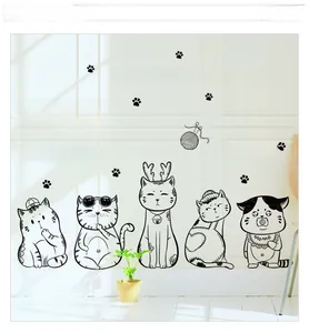 Detail of minimalist black cat wall stickers in various poses on a white living room wall