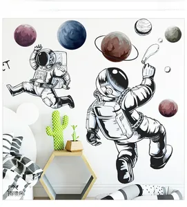 Detail of astronaut and planet wall stickers applied to a modern white bedroom wall