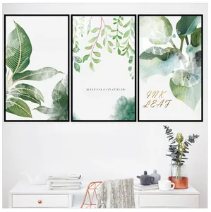 Close-up of Nordic green leaf wall art triptych with black frames in a cozy living room