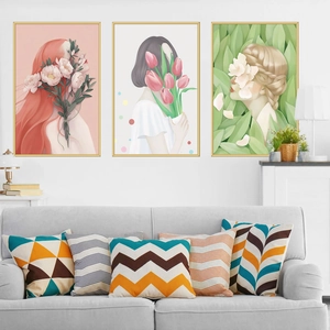 Three-piece modern wall art with female figures and geometric pillows on a gray sofa
