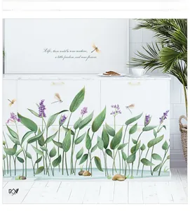 Close-up of green leaf and dragonfly wall decals on a modern white cabinet surface