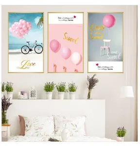 Detail of three-piece pink aesthetic wall art with gold frames over a cozy bed
