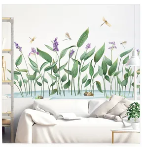 Detail view of green leaf wall stickers with dragonflies and floral accents on living room wall