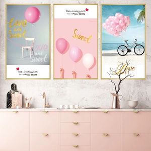 Pink beach bicycle and balloon wall art prints with gold frames in a modern interior