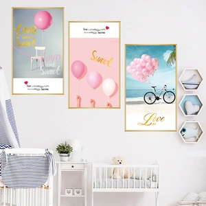 Trio set of pink dream balloon posters with golden frames in a cozy nursery room