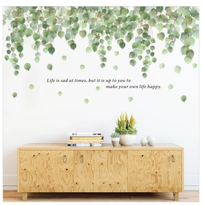 Detail of green leaf wall sticker with motivational life quote on a white home wall