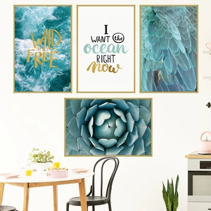 Set of 4 modern blue wall art prints with gold frames featuring waves and feathers