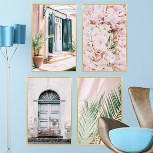 Set of four scenic wall art pieces with gold frames on a modern blue living room wall