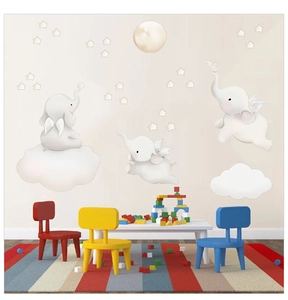 Detail of cute elephant wall decals with clouds and stars in a warm nursery playroom