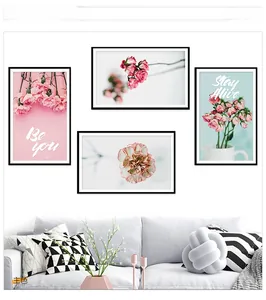 Detail view of a 4-piece set of pink floral wall art with black frames on white wall