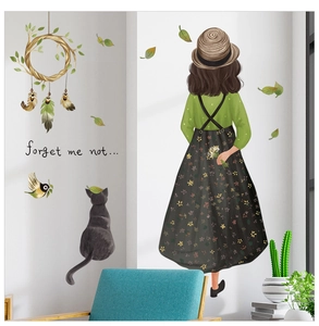 Détail d'un autocollant mural avec fille, chat noir et feuilles vertes pour décoration