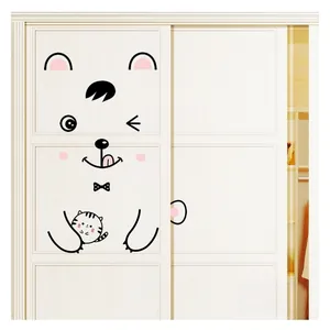 Vue détaillée d'un autocollant ours de dessin animé appliqué sur une porte de placard blanche
