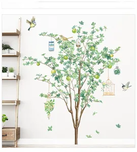 Détail d'autocollant mural arbre vert avec oiseaux et cages sur mur blanc
