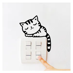 Detail view of sleeping cat wall decal applied above a modern light switch on white wall