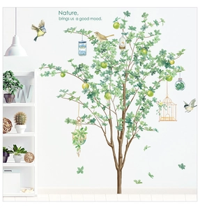 Détail d'un sticker mural nordique arbre vert avec oiseaux et cage à oiseaux suspendue