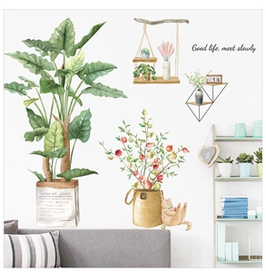 Close-up of watercolor green plant wall decals on a white wall above a sofa