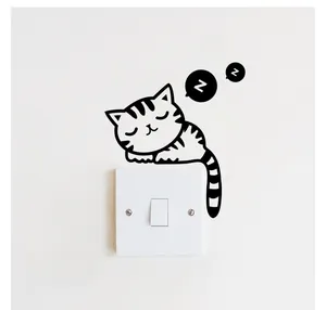 Detail of creative sleeping cat wall sticker applied on a white light switch panel