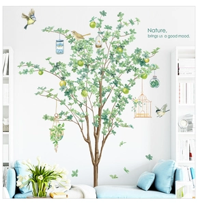 Détail de stickers muraux arbre avec oiseaux et pommes dans un salon moderne