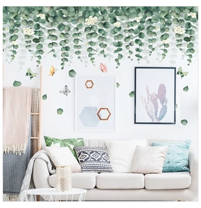 Detail of hanging eucalyptus leaves wall stickers with butterflies in a modern living room