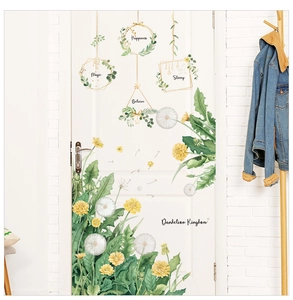 Detail of Nordic dandelion wall sticker with golden hanging ornaments on a white door