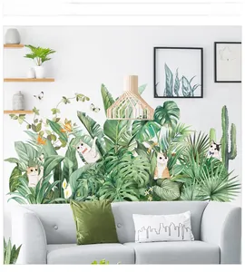 Detail view of tropical monstera leaves and cartoon cat wall stickers on white bedroom wall