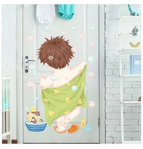 Detail of waterproof cartoon boy wall sticker on white door in a bright nursery setting