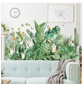 Detail of tropical plant wall stickers with green leaves and cute cats in a living room